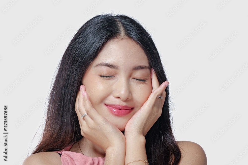 Gorgeous young Asian woman wearing pink dress touching her cheeks with a joyful expression. Gorgeous young Asian woman wearing pink dress touching her cheeks with a joyful expression.