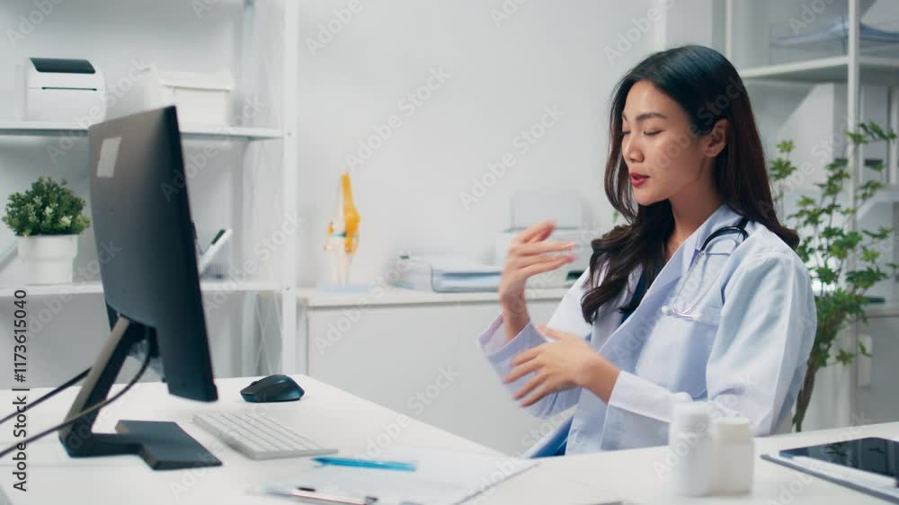 Young asian female doctor using computer making a video call, talking to patient sits in office at hopistal. Asian doctor remote consultation, telehealth, online diagnostic and advising her patient. Young asian female doctor using computer making a video call, talking to patient sits in office at hopistal. Asian doctor remote consultation, telehealth, online diagnostic and advising her patient.