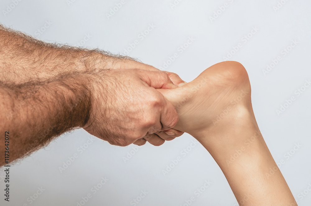 Fototapeta premium Massage of female toes by strong male hands. Foot massage. Gray background. Spa treatments..