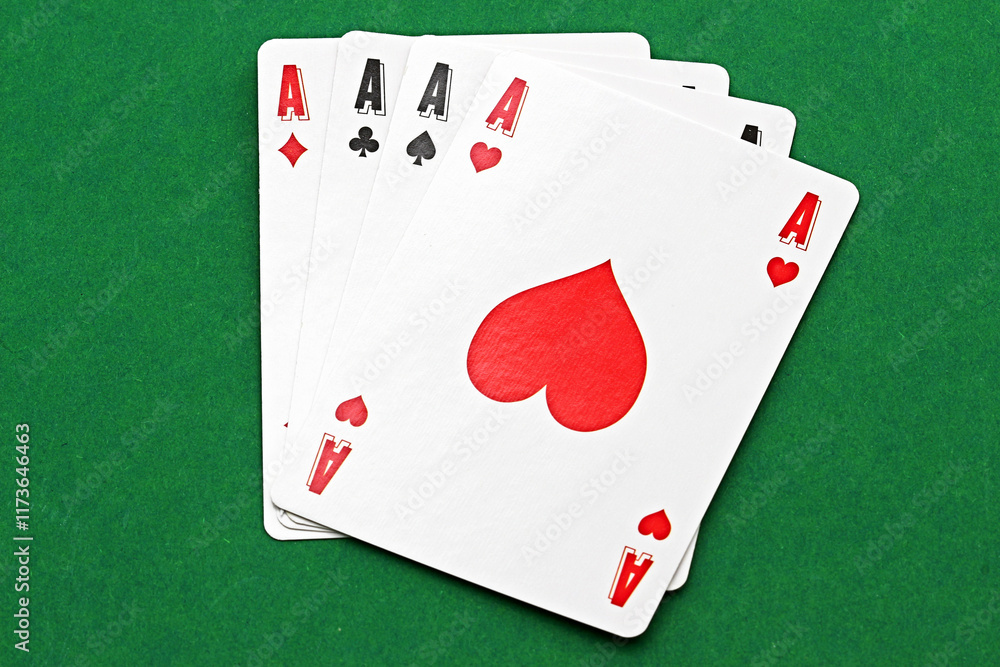Obraz premium Close-up of playing cards with the image of four aces. Close-up of playing cards with the image of four aces isolated on a green background.