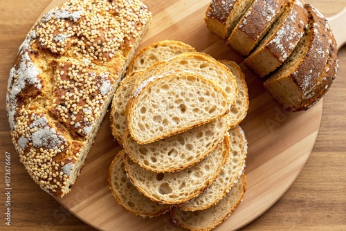 Sliced artisan bread with sesame seeds on wooden board close-up. photo