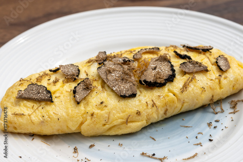 French omelette with mushrooms, fresh farmers eggs and black summer truffle mushroom in pieces for making truffle dishes with tasty aroma photo