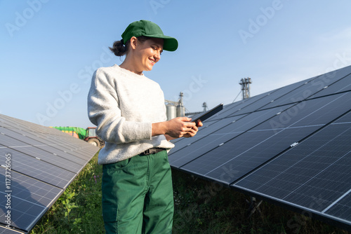 Female farmer with digital tablet on a modern farm using solar panels