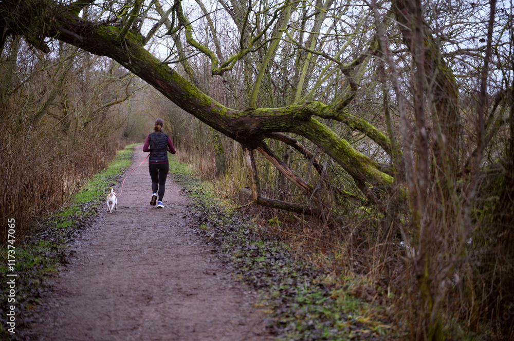 Woman and a dog running in the park 