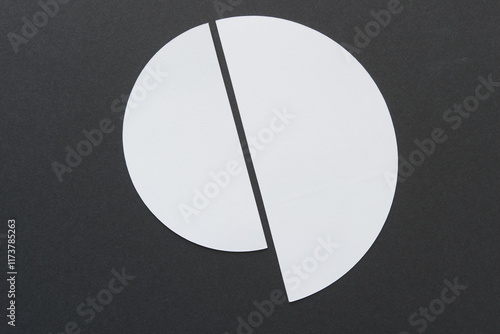 two machine-cut white paper semi circles on black paper (golden spiral or shell shape) photo