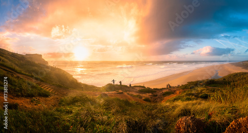 Panoramic view of Nazare beach, people watching waves during sunset, Portugal