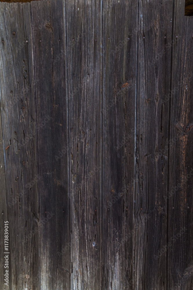 Naklejka premium A close-up of weathered, dark gray wooden planks forming a textured surface