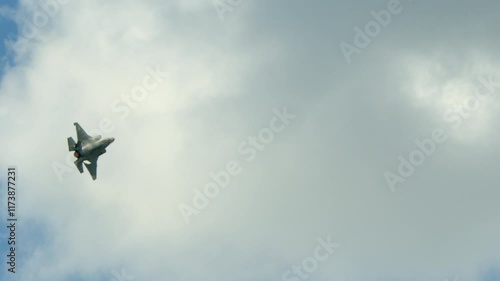 An F-35 warplane banks hard in the sky.