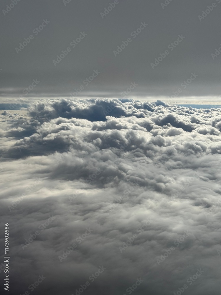 Naklejka premium Somewhere above the white and grey clouds
