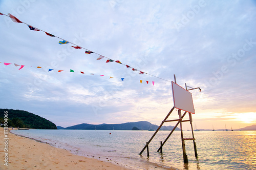 Colorful Flags Against a Scenic Beach Sunset with Mountains photo