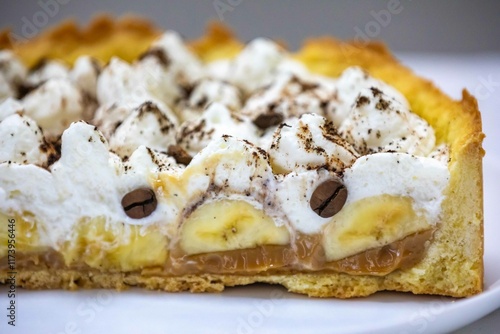 Authentic banoffee cake with banana and caramel sauce filling sprinkled with grated dark chocolate and coffee . English traditional pie photo