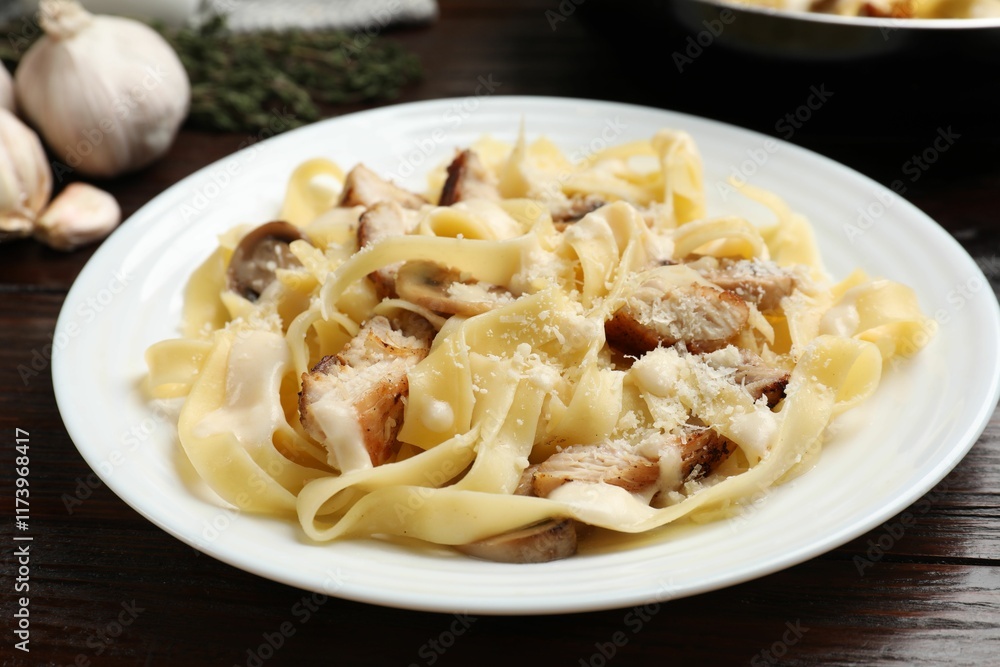 Tasty Alfredo pasta with chicken and mushrooms on wooden table, closeup Tasty Alfredo pasta with chicken and mushrooms on wooden table, closeup