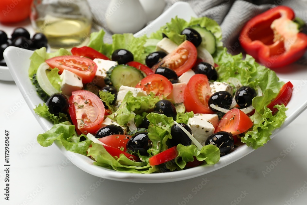 Delicious fresh Greek salad on white table, closeup Delicious fresh Greek salad on white table, closeup