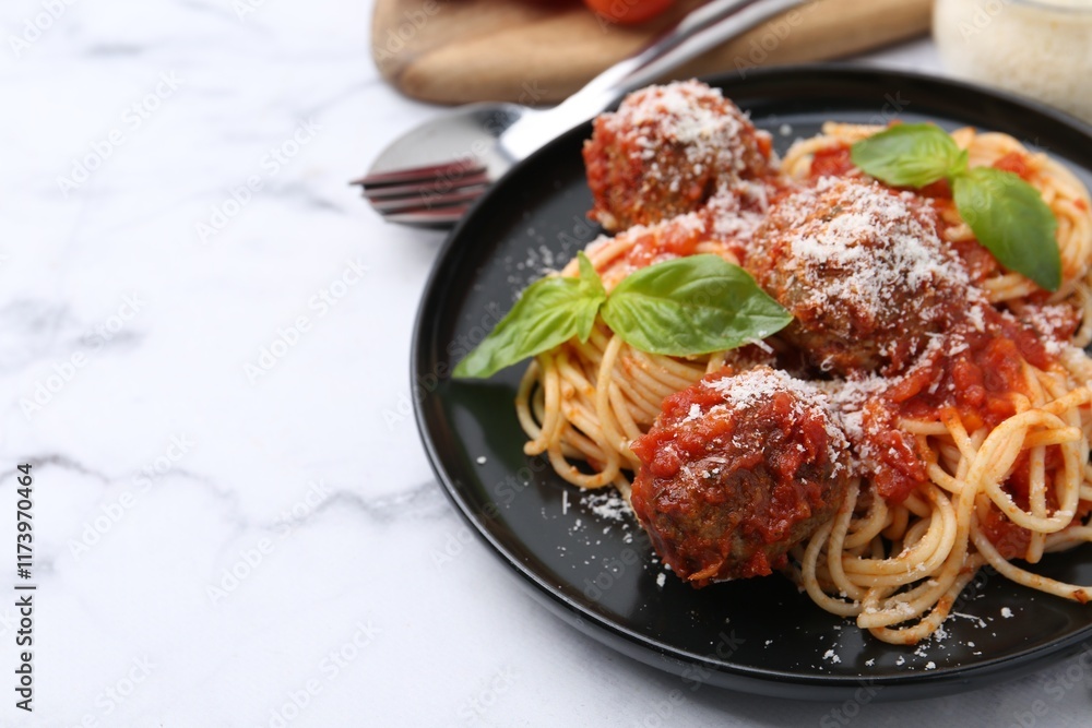 Delicious pasta with meatballs, basil and cheese on white marble table, closeup. Space for text