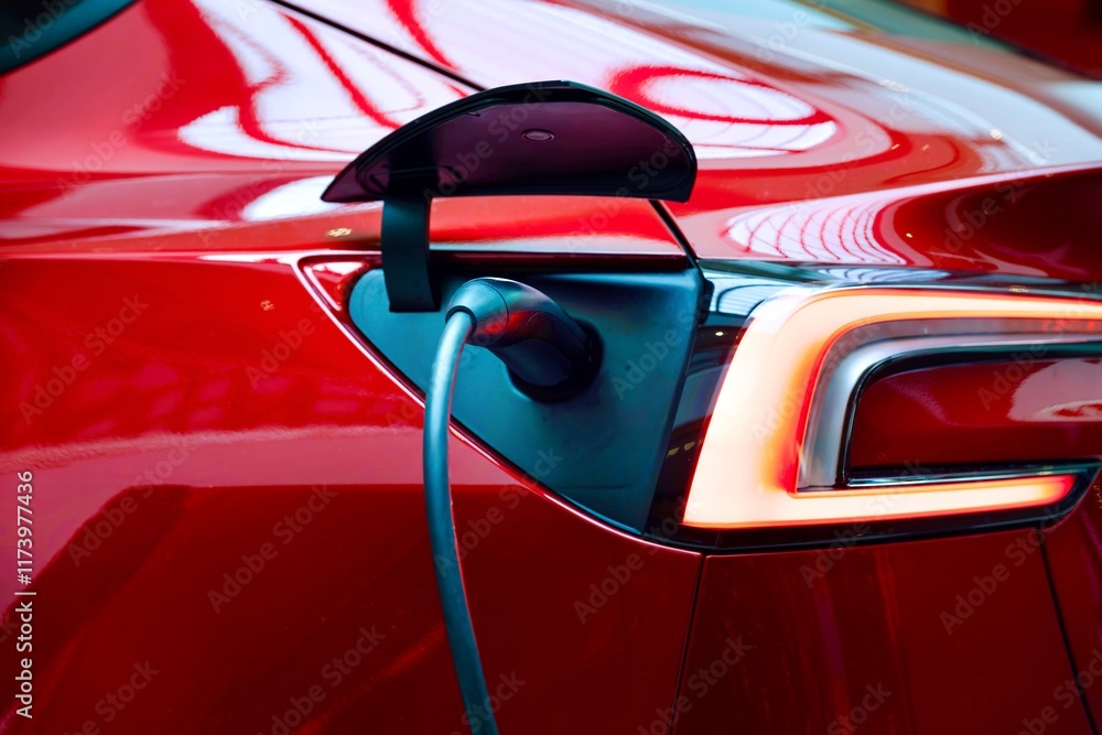 Fototapeta premium Selective focus of a red EV car is charging its battery. 