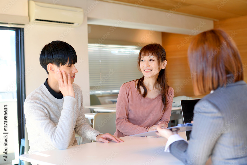 テーブルで会話をする複数人のアジア人男女 テーブルで会話をする複数人のアジア人男女