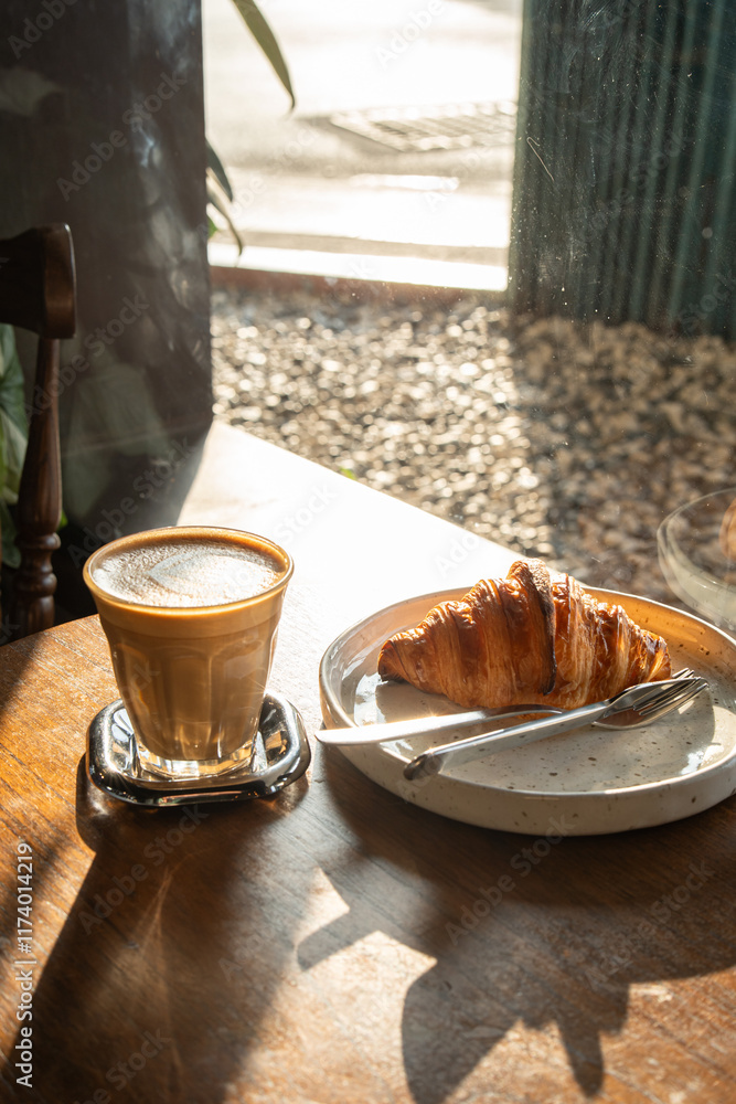 Hot coffee latte with latte art milk foam in cup mug with Croissant on wood desk on top view. As breakfast In a coffee shop at the cafe,during business work concept,vintage style