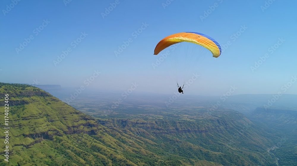Paraglider soars over vast mountain range on sunny day. Paraglider soars over vast mountain range on sunny day.