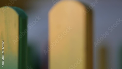 The colorful painted wooden boards on the fence around a playground are illuminated by the rays of the setting sun. Pula, Croatia - January 3, 2025