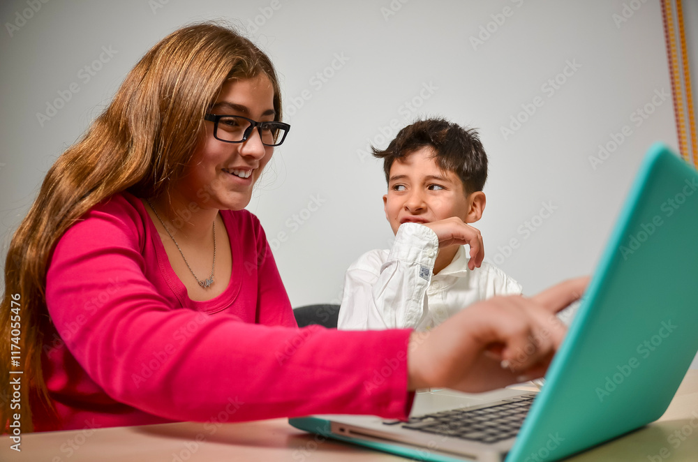 Teenage girl helping little boy using laptop for homeschooling Teenage girl helping little boy using laptop for homeschooling