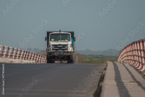 Obraz na płótnie Truck or lorry driving over a bridge in ziguinchor city in southern part od Senegal. Rough road over bridge of casamance river, sunny day, transporting goods. w salonie