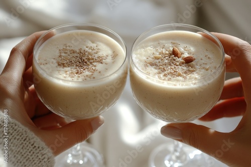 Two creamy, dreamy almond smoothies topped with crunchy nuts, perfect for a healthy treat.