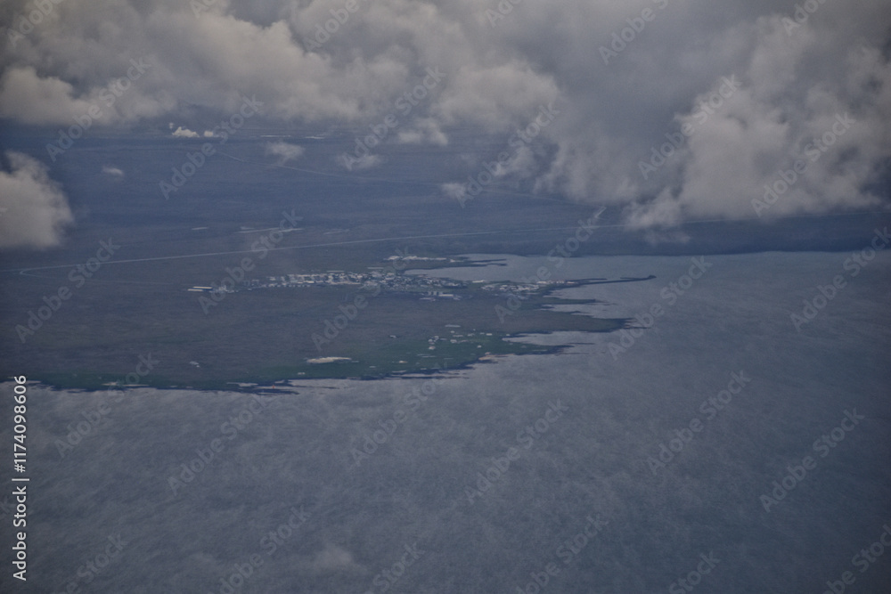 Obraz premium Iceland from airplane through clouds. Aerial scenic view of Iceland landscape. Travel vacation concept. Europe.