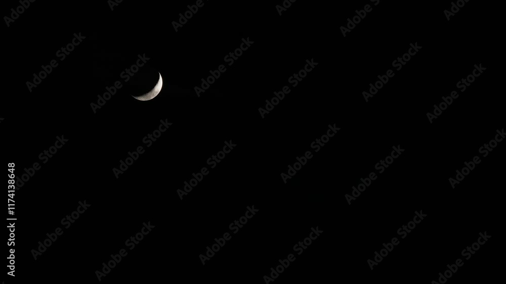 Tokyo, Japan - Janaury 4, 2025: A Crescent moon gradually covered with Moving clouds in Tokyo