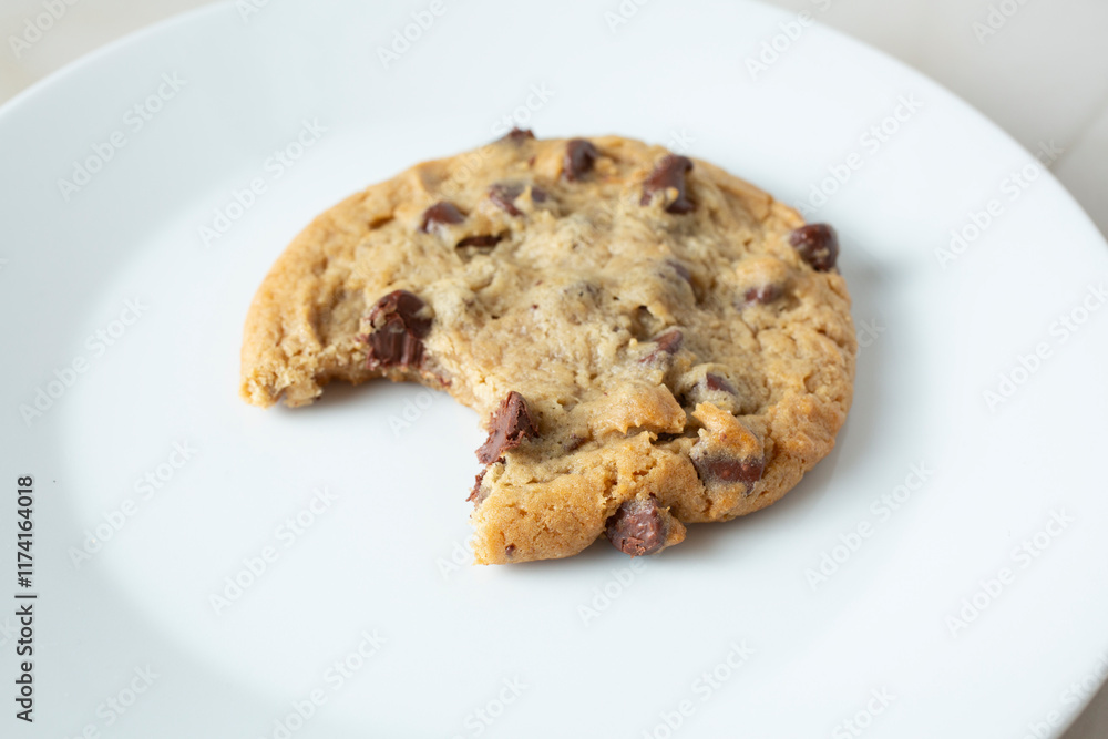 A closeup view of a chocolate chip cookie, featuring a bite mark. A closeup view of a chocolate chip cookie, featuring a bite mark.