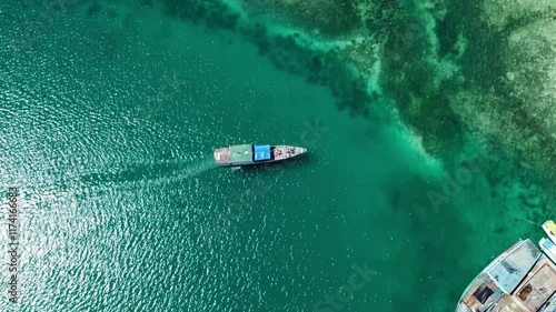 A wooden boat moves slowly in shallow waters.
