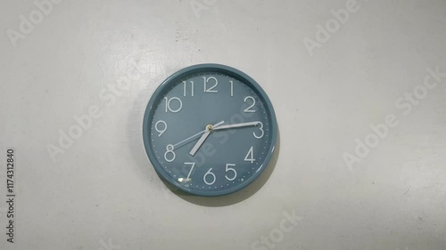 Wallpaper Mural A blue wall clock shows the time as a little past 7. The simple design features white numbers and hands against a plain background, creating a minimalist appearance. Torontodigital.ca