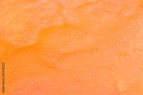 Energetic orange liquid with foamy bubbles. Perfect for summer and tropical themes