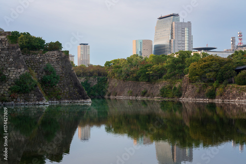 View of the inner moat and ramparts around Osaka Castle and the surrounding urban landscape on an early autumn morning, Osaka, Japan photo