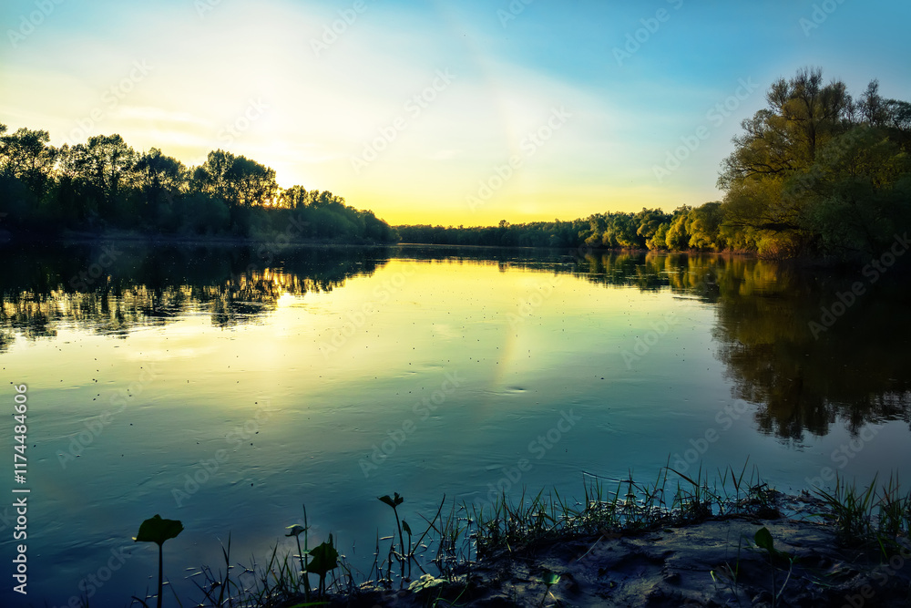 Obraz premium Unusual atmospheric phenomena. Very bright double halo (parhelic ring) over river at moment of evening sunset, windless spring day. Average flow of Don River. Mock sun with reflection in water