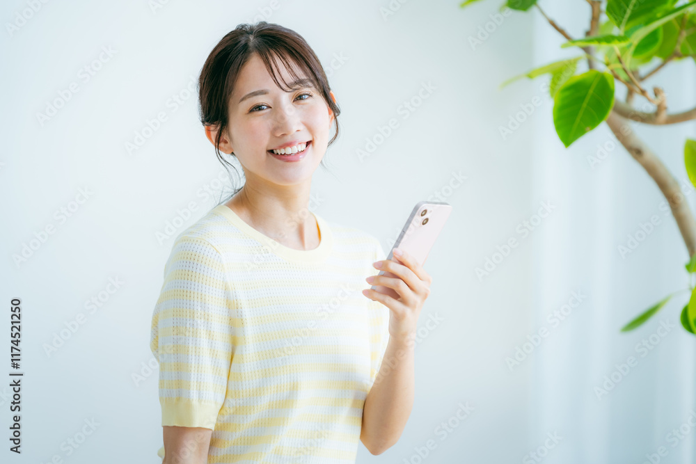 部屋でスマホを操作する女性 部屋でスマホを操作する女性