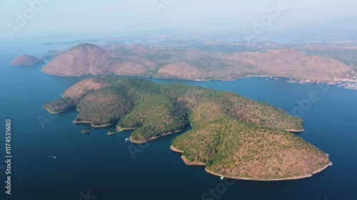 Aerial landscape view of Sri Nakarin Dam is a water storage dam for electricity generation and agriculture in the middle of a valley in Kanchanaburi, Thailand.
