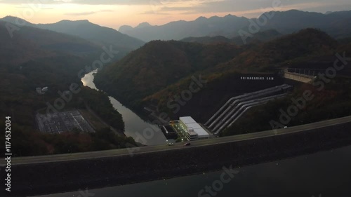 Aerial landscape view of Sri Nakarin Dam is a water storage dam for electricity generation and agriculture in the middle of a valley in Kanchanaburi, Thailand.