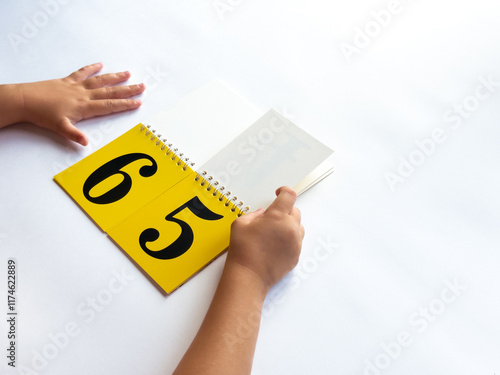 Child learning numbers with flashcards and hands on a white background photo