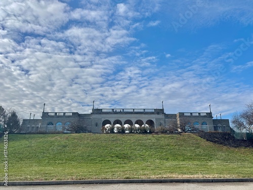 Elegant historic stone building on a hill with an expansive cloudy sky photo