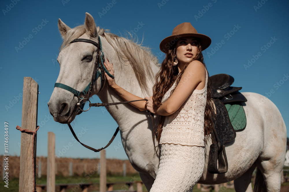 Woman in hat with white horse on ranch on sunny day Woman in hat with white horse on ranch on sunny day