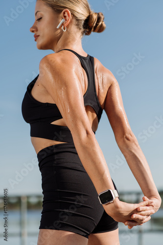 Athletic girl in sportswear training or doing exercises outdoors photo