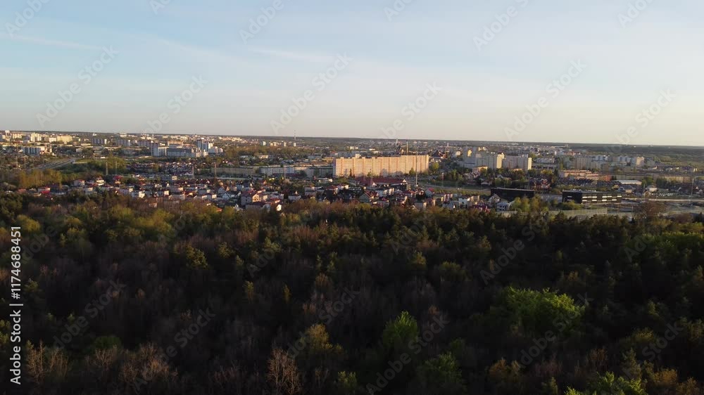 Aerial view of City and Forest in Poland at sunrise. Drone shot flying over spruce conifer treetops, nature background footage in 4K resolution Aerial view of City and Forest in Poland at sunrise. Drone shot flying over spruce conifer treetops, nature background footage in 4K resolution
