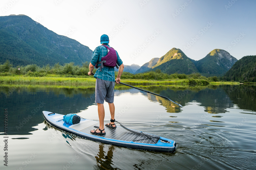 Rear view of man exploring river on paddle board Rear view of man exploring river on paddle board