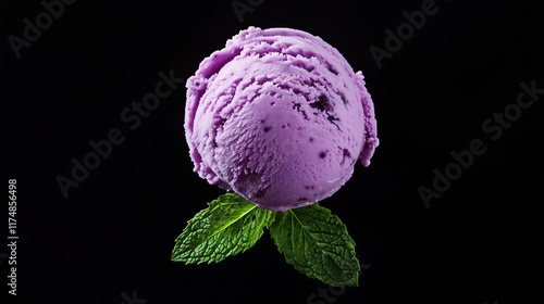 Blueberry (gelato) ice cream ball, with a mint leaf isolated on black background