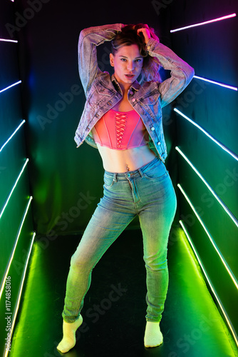 Psychedelic girl in tight fitting figure hugging denim jeans and bodice wearing jacket with arms over her head photo