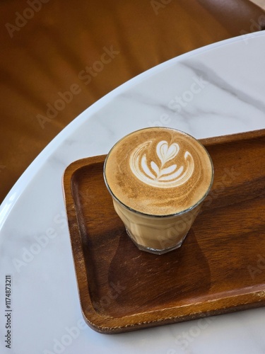 Nice Texture of Latte art on hot latte coffee . Milk foam in heart shape leaf tree on top of latte art from professional barista artist	
