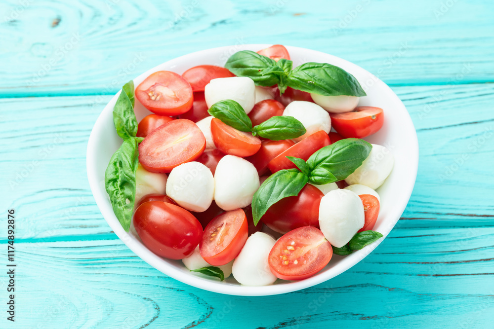 Basil leaves , cherry tomatoes and mozzarella cheese . In bowl food photography Basil leaves , cherry tomatoes and mozzarella cheese . In bowl food photography
