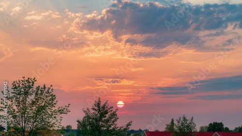 Beautiful sunset sky with scattered light clouds in shades of orange, pink, and blue over the horizon