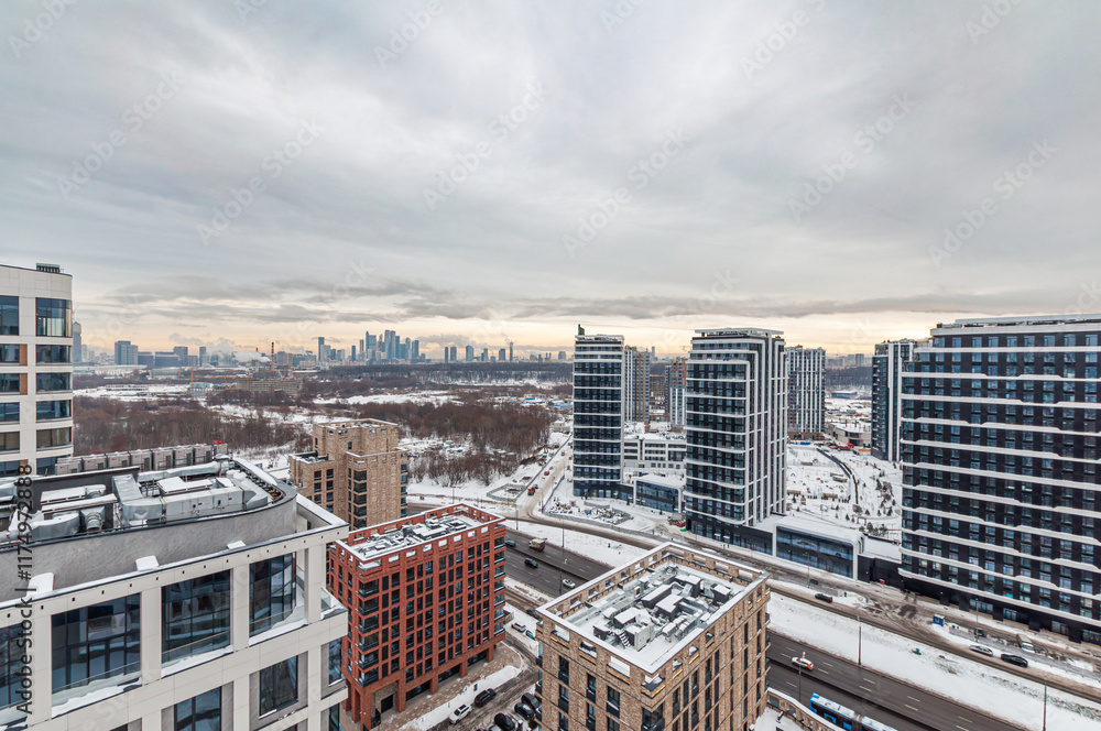 New residential area under construction with high-rise buildings, close to the Moskva River. Winter, snow, overcast. New residential area under construction with high-rise buildings, close to the Moskva River. Winter, snow, overcast.