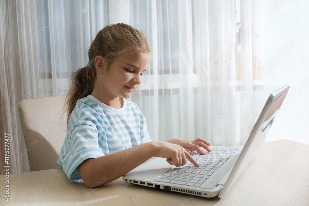 child girl show sight thumbs up, is using a laptop and communicates on the Internet at home. homeschooling, distant learning, online e child girl show sight thumbs up, is using a laptop and communicates on the Internet at home. homeschooling, distant learning, online e